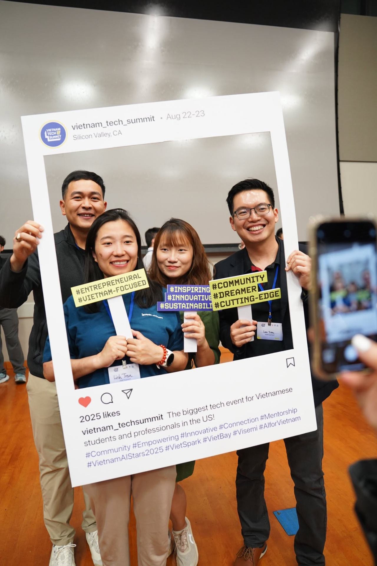 A group of attendees smiling while a friend photographs them
